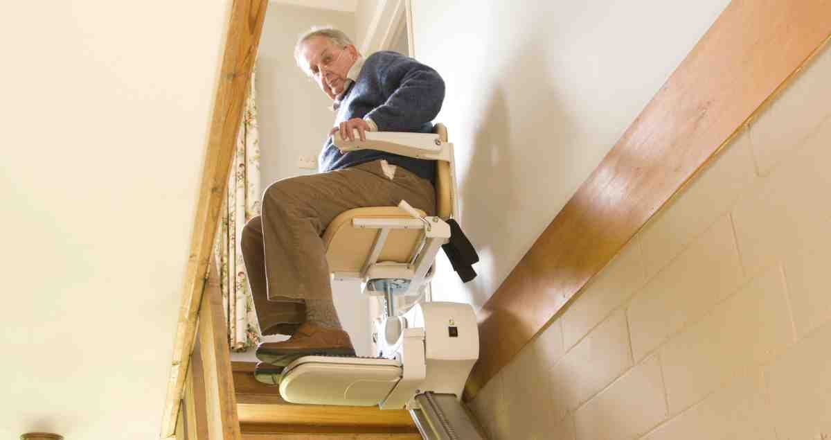Stair Elevator For Seniors ishowing in the image where a senior is going upside via stairlift easily